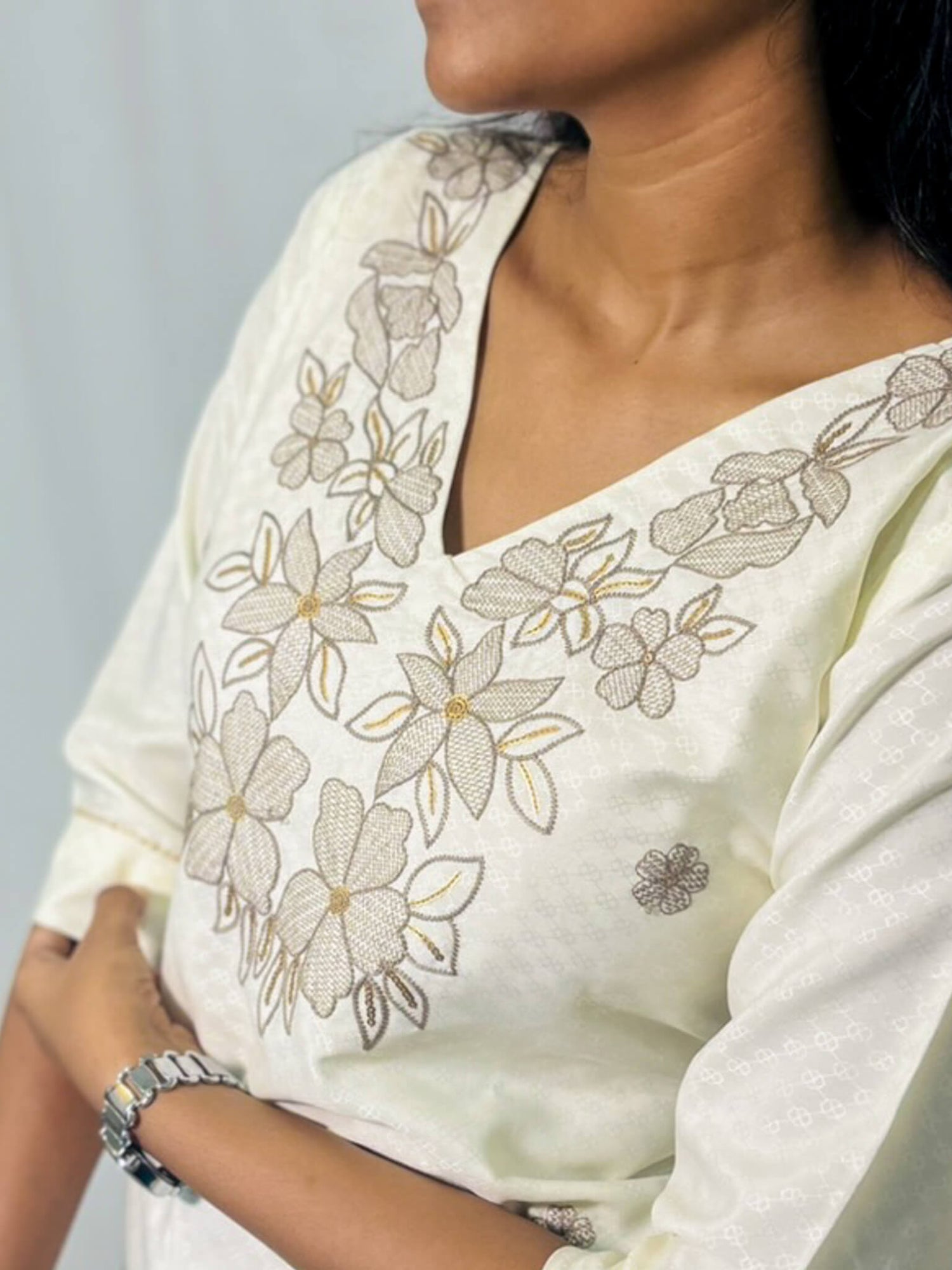 White saree with floral embroidery on a plain background