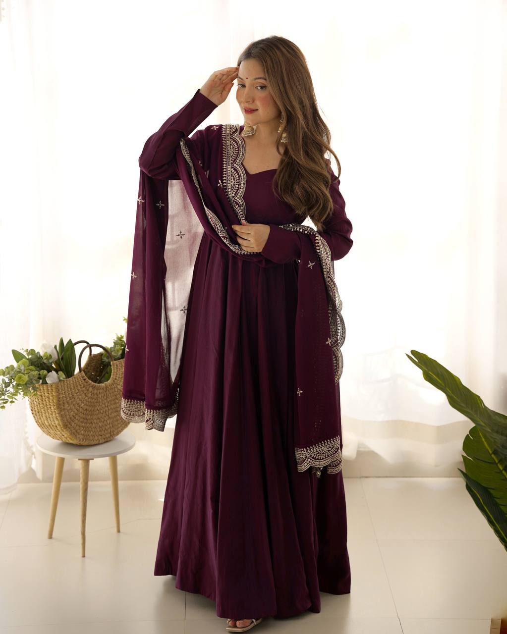 Woman wearing a long purple dress with a matching shawl indoors.