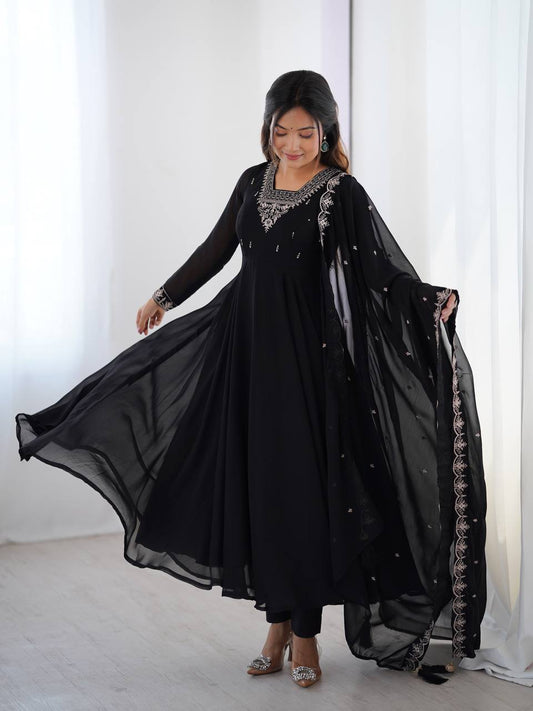Woman wearing a black dress with embroidery in a bright room