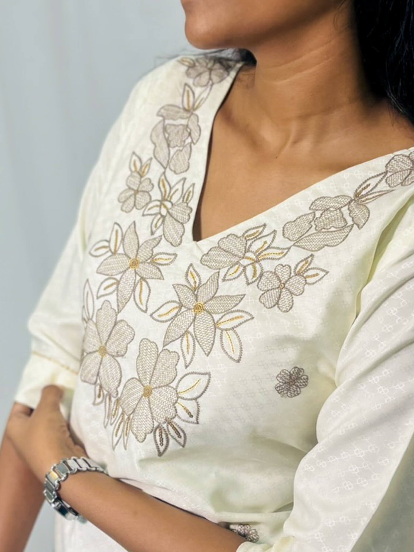 White saree with floral embroidery on a plain background