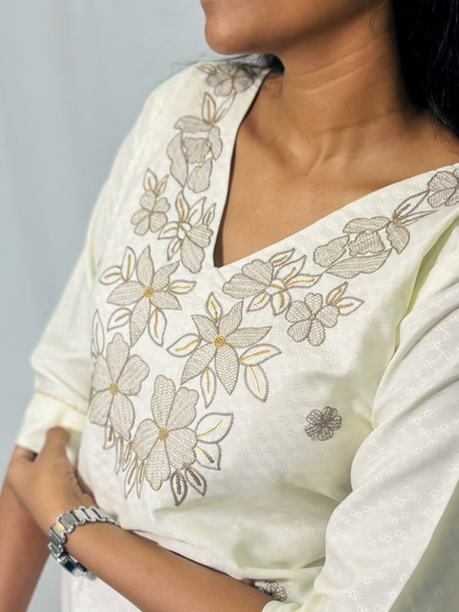 White saree with floral embroidery on a plain background