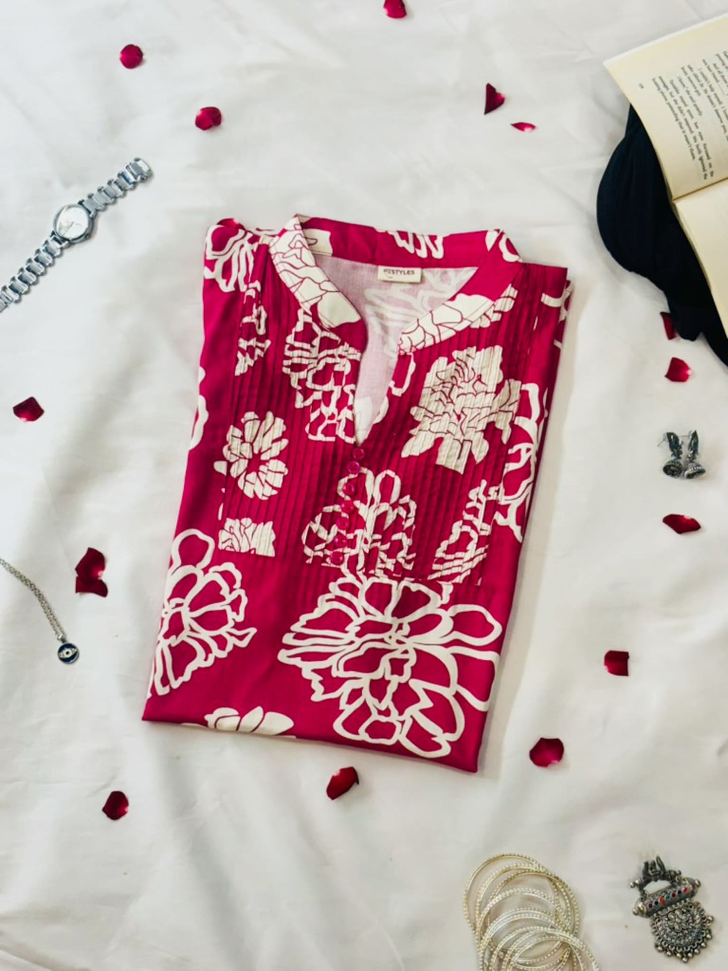 Red floral dress on a white surface with decorative elements