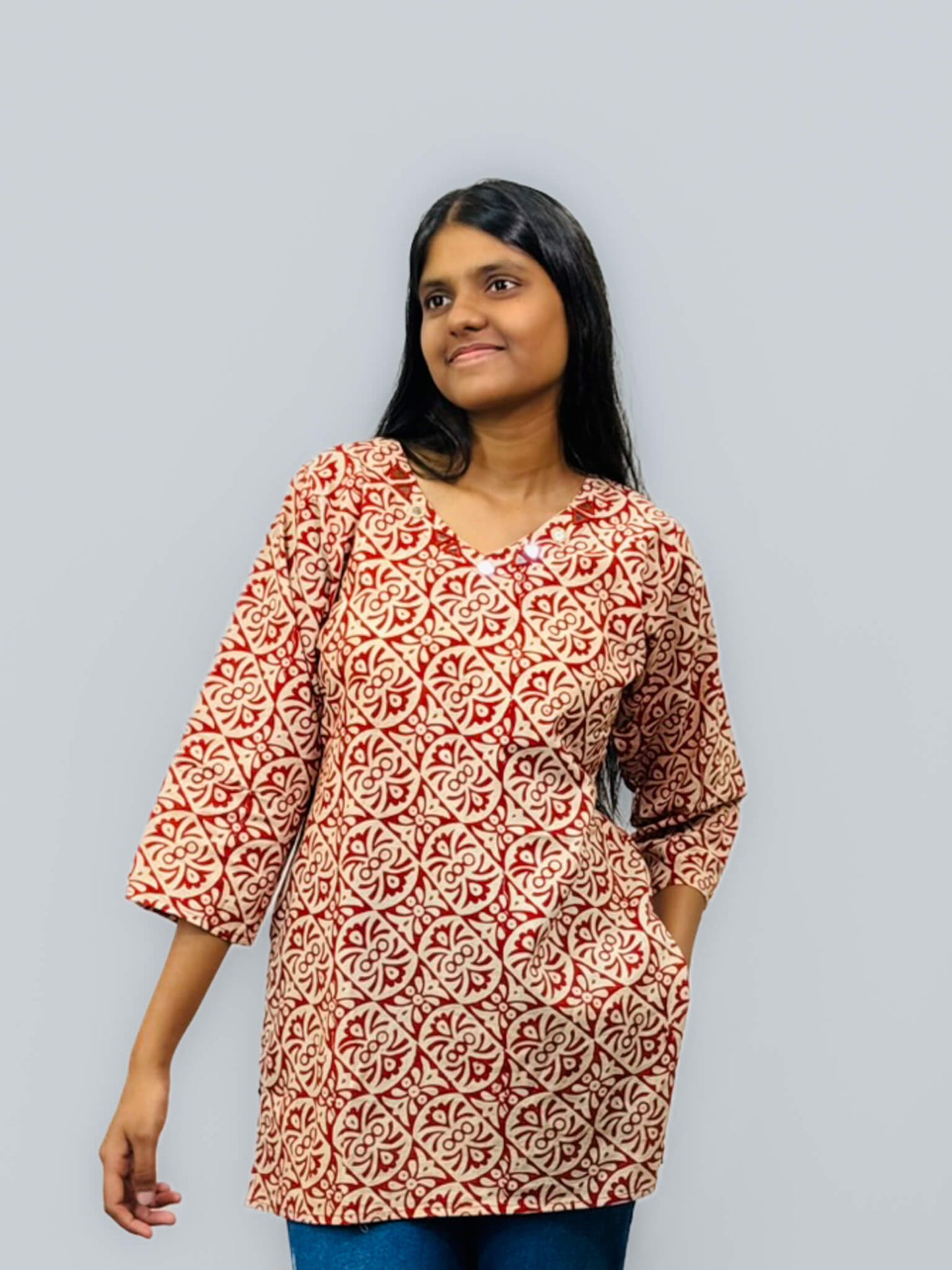 Woman wearing a patterned red and white dress against a gray background