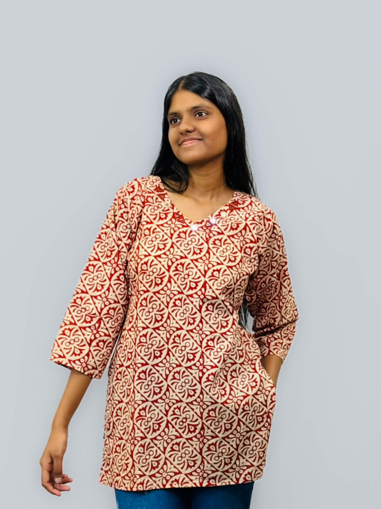 Woman wearing a patterned red and white dress against a gray background