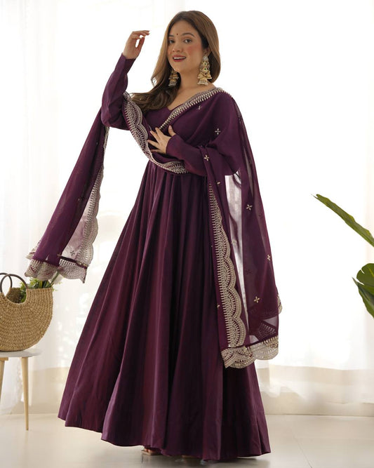 Woman wearing a purple traditional outfit with a matching shawl indoors.